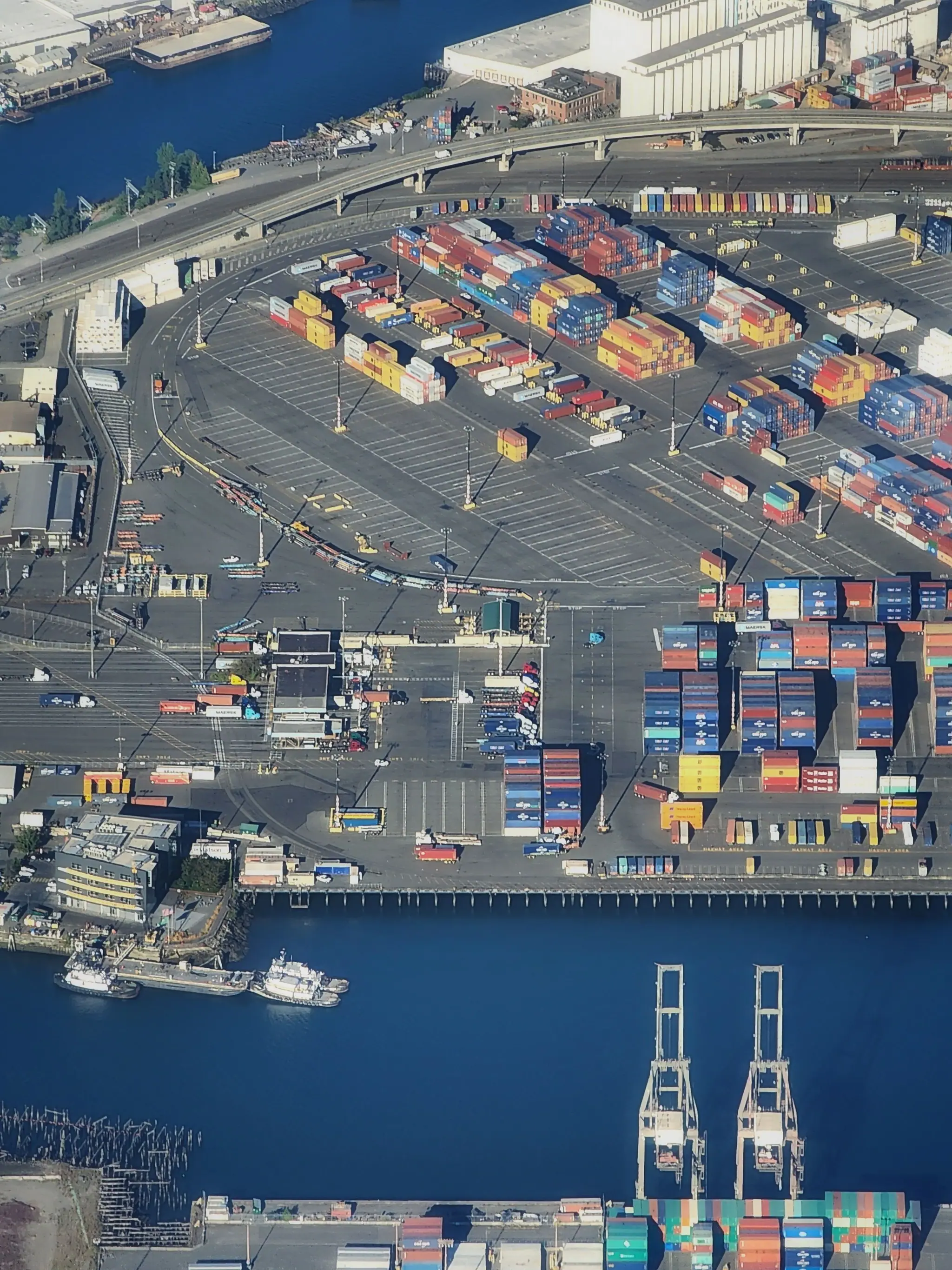 Aerial view of a container terminal with stacked containers and quay cranes