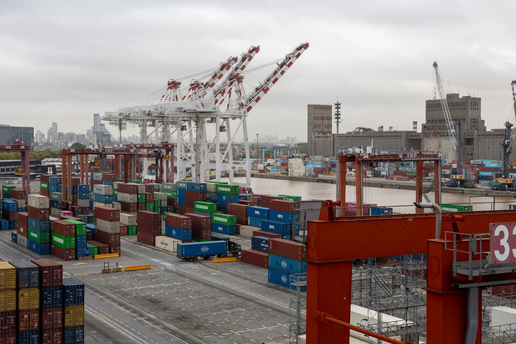 Port skyline with white container cranes over stacked containers
